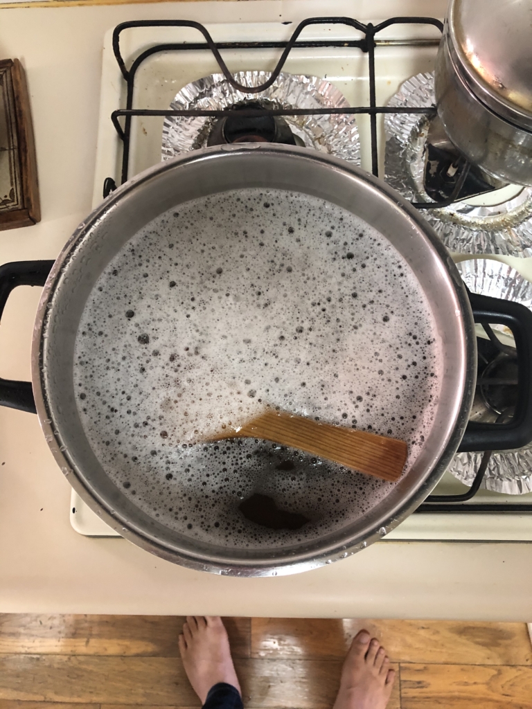 手作りビールのキット缶を鍋に入れて、しゃもじでかき混ぜている所